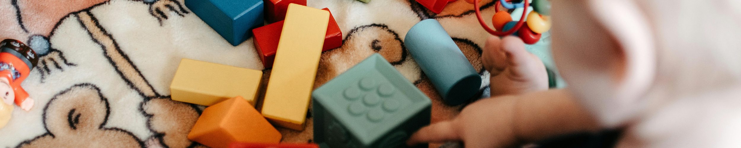 Un bébé joue avec des cubes en bois